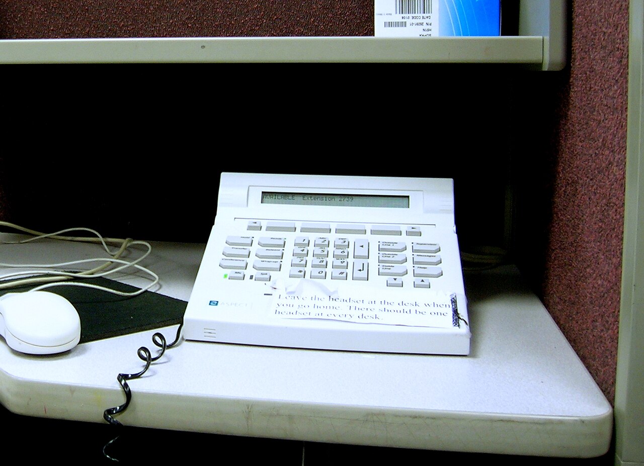 A desk telephone on a call-centre cubicle desk