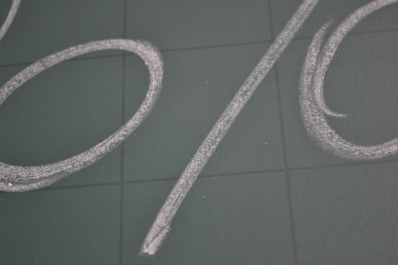 A percentage sign drawn in chalk on a chalkboard